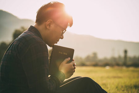 A TUKSDA member reading Scripture outdoors